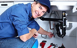 A plumber man fixing wash basin witha smiling face
