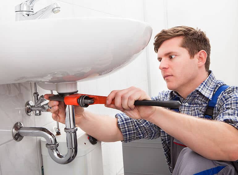 A plumber fixing a handwash basin