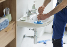 Repairman unclogging a bathroom sink