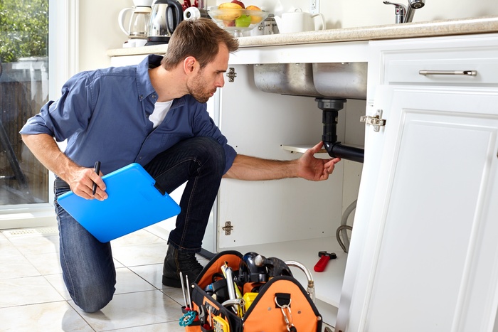 Professional plumber doing renovation in kitchen