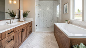 A newly remodeled bathroom showcasing a natural wood cabinet with a white marble countertop