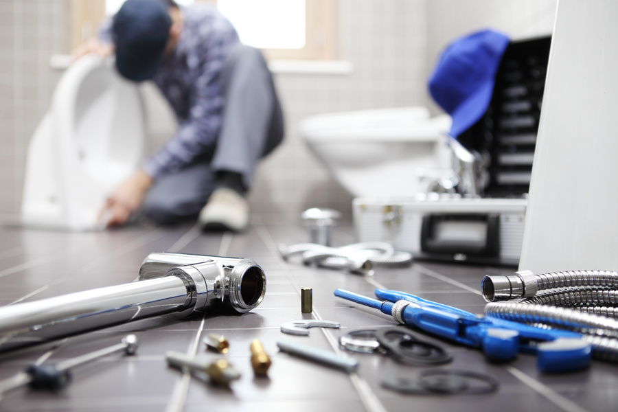plumber at work in a bathroom - plumbing repair service